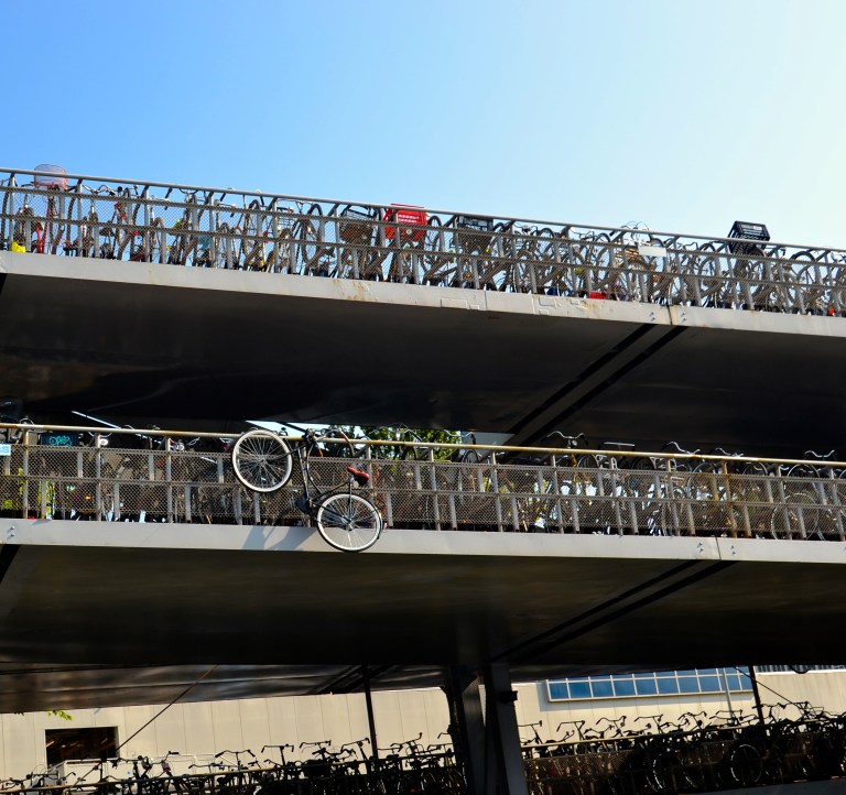 Bicycle hanging from bridge.